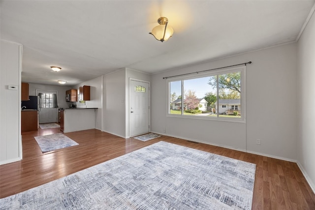 unfurnished living room with wood finished floors and baseboards