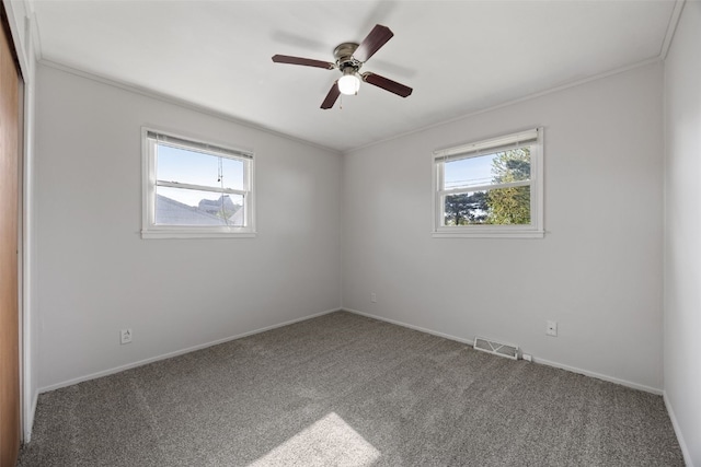 unfurnished room featuring plenty of natural light, carpet floors, crown molding, and a ceiling fan
