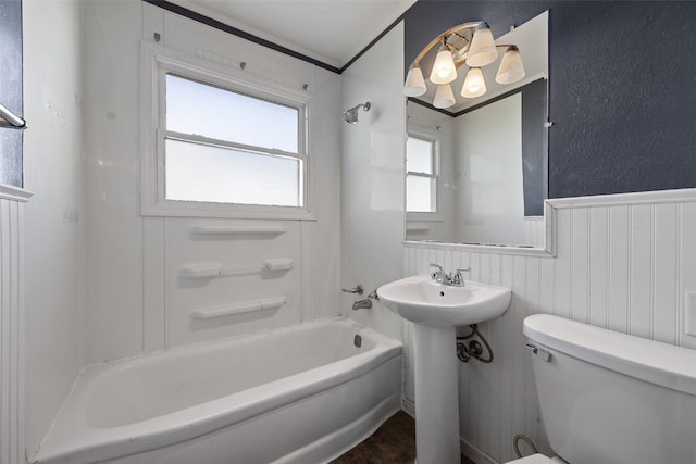 full bath with toilet, shower / tub combination, wainscoting, a chandelier, and a sink