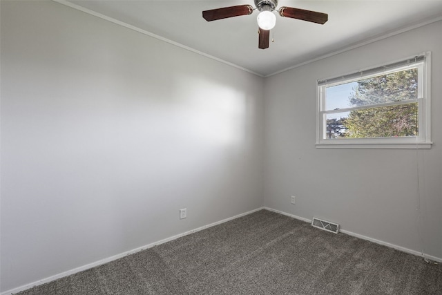 spare room featuring ceiling fan, dark colored carpet, baseboards, and crown molding