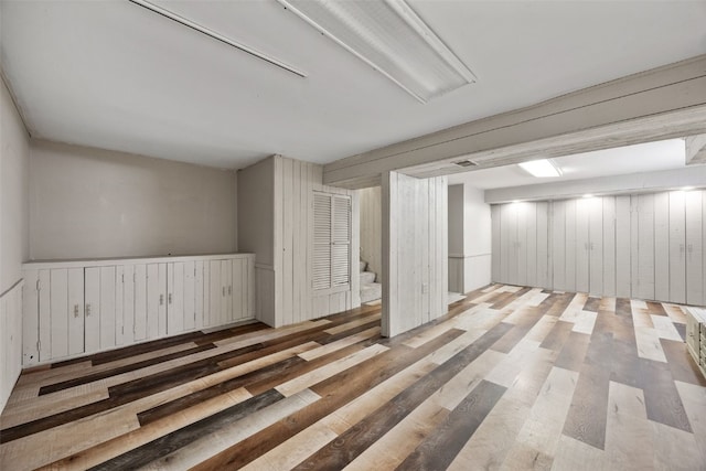 finished basement with stairs and wood finished floors