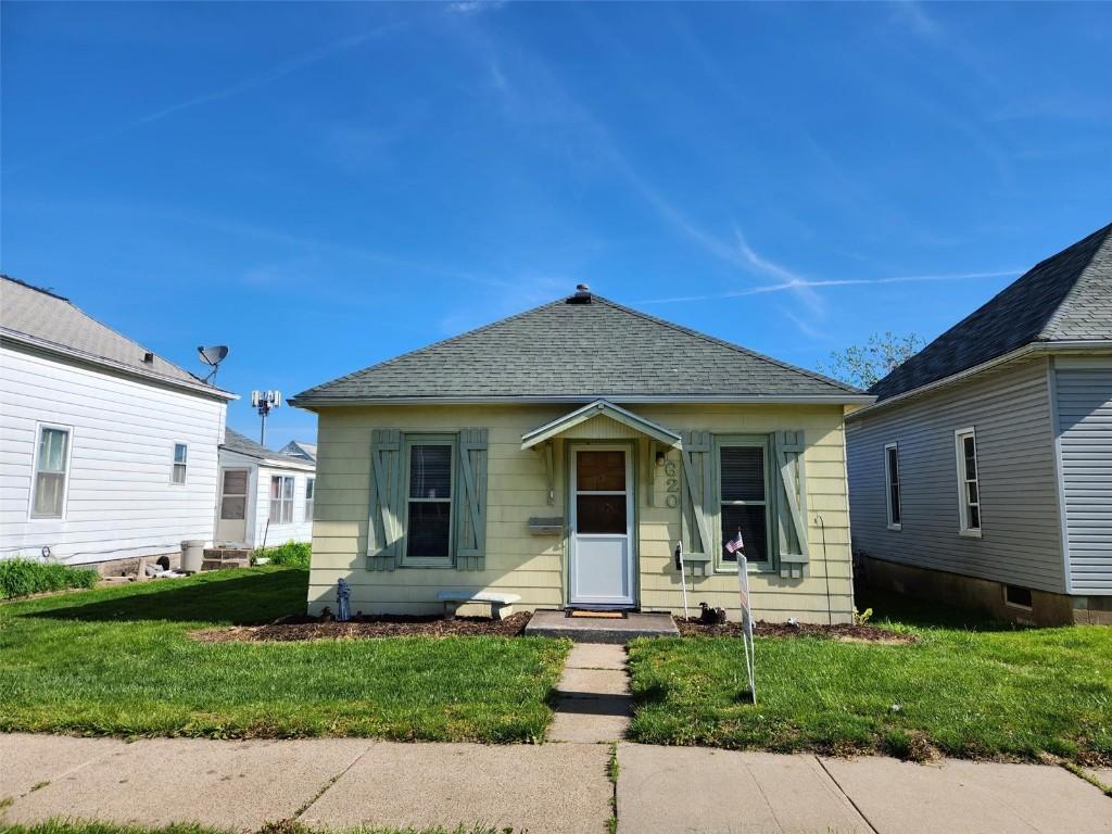 view of front of home featuring a front yard and roof with shingles