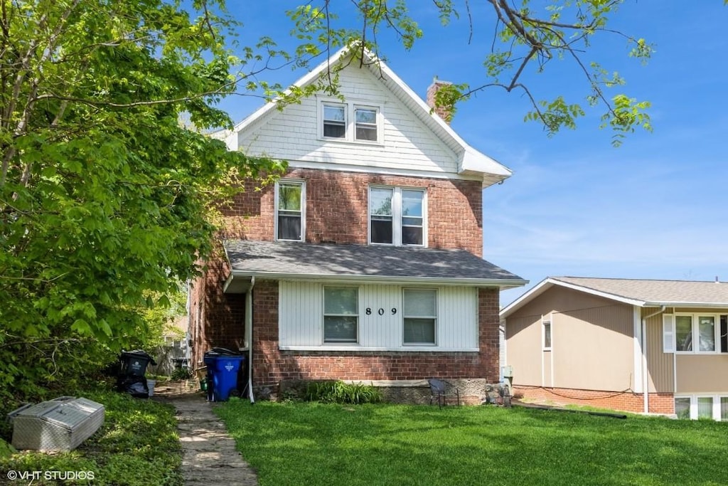 traditional style home with brick siding and a front yard