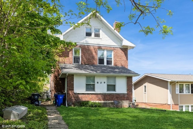 traditional style home with brick siding and a front yard