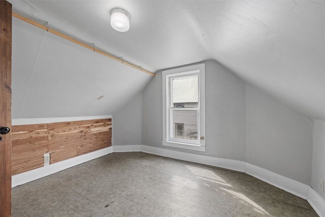 bonus room with vaulted ceiling and baseboards