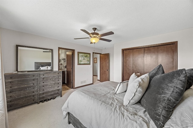 bedroom featuring light colored carpet, a closet, and a ceiling fan