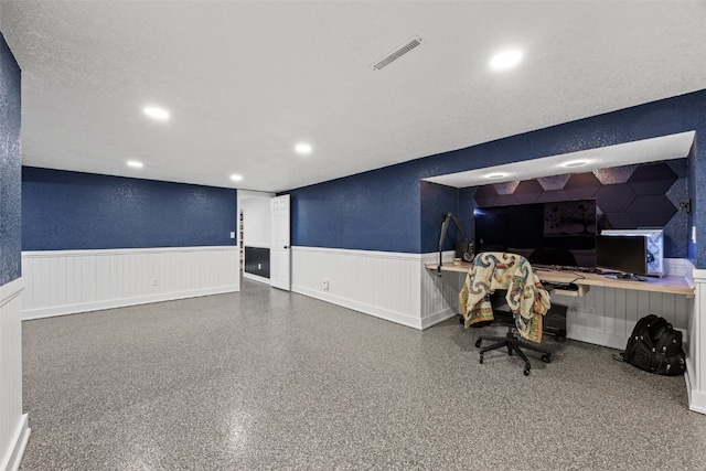 office with a wainscoted wall, a textured wall, and recessed lighting