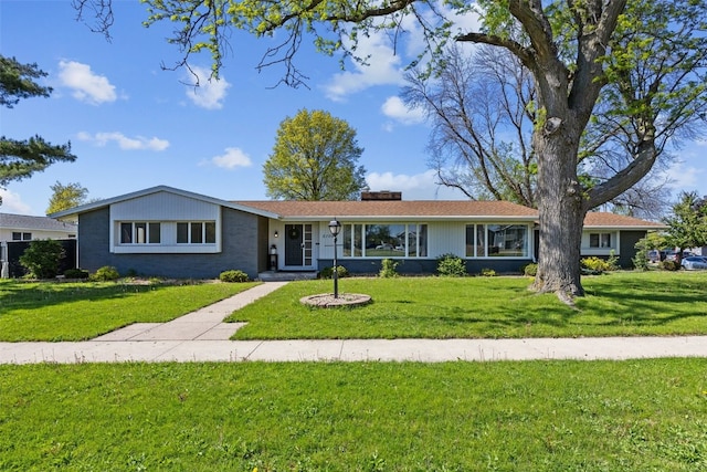 ranch-style home featuring a front lawn and a chimney