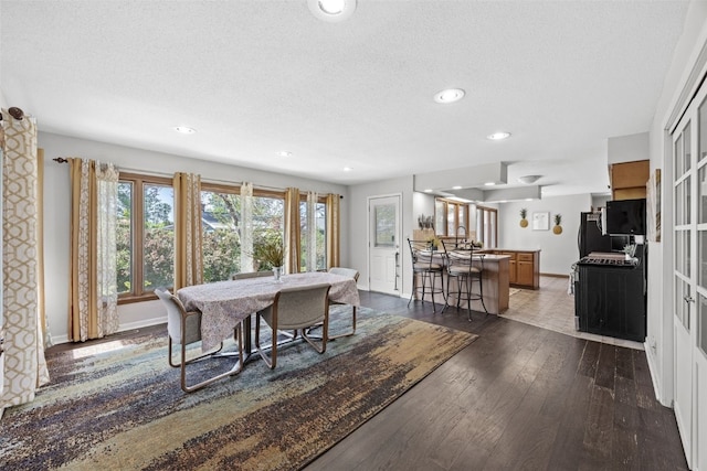 dining room with dark wood finished floors, recessed lighting, a textured ceiling, and baseboards