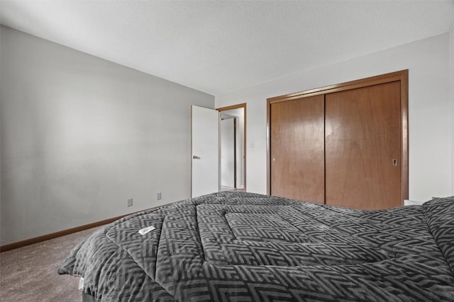 carpeted bedroom with a closet and baseboards