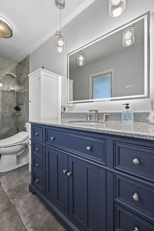 bathroom featuring toilet, a tile shower, vanity, and tile patterned flooring