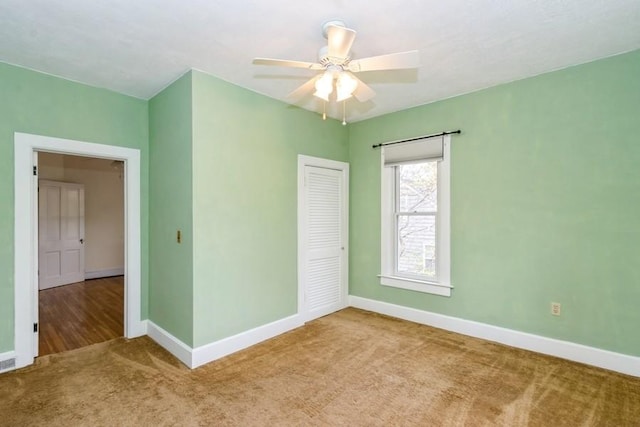 spare room with carpet, baseboards, and ceiling fan