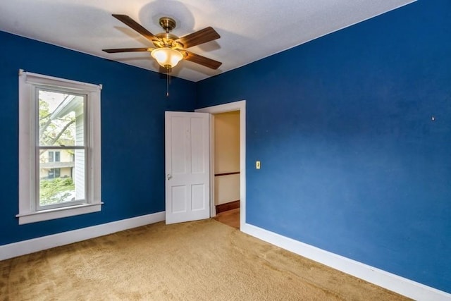 unfurnished bedroom featuring carpet flooring, baseboards, and a ceiling fan