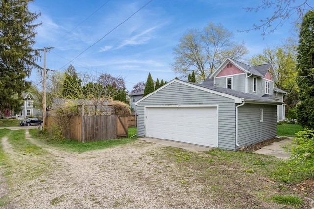 garage featuring fence and driveway