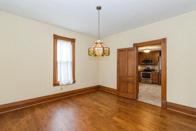 empty room with wood finished floors and baseboards