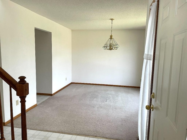 empty room featuring carpet, a chandelier, baseboards, a textured ceiling, and stairway