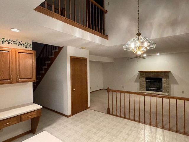 interior space with a brick fireplace, baseboards, carpet, and a ceiling fan