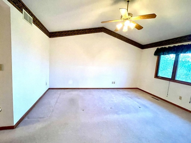 unfurnished room with ornamental molding, vaulted ceiling, baseboards, ceiling fan, and carpet floors