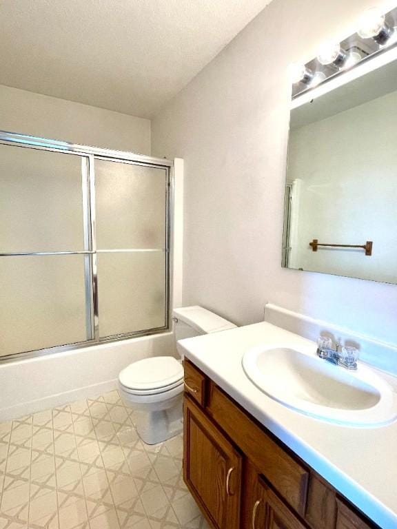 full bath with vanity, toilet, combined bath / shower with glass door, and tile patterned floors
