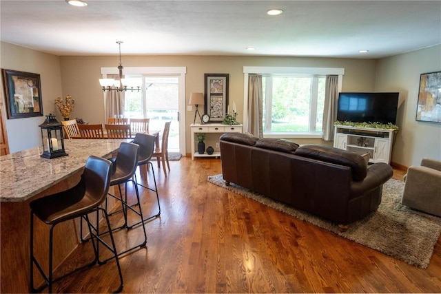 living area featuring healthy amount of natural light, a chandelier, wood finished floors, and recessed lighting