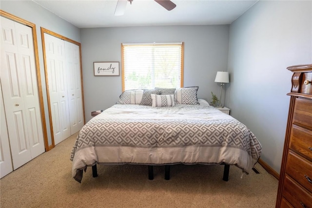 bedroom featuring carpet flooring, multiple closets, and ceiling fan