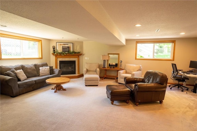 living area with light colored carpet, recessed lighting, a tile fireplace, a textured ceiling, and an office area