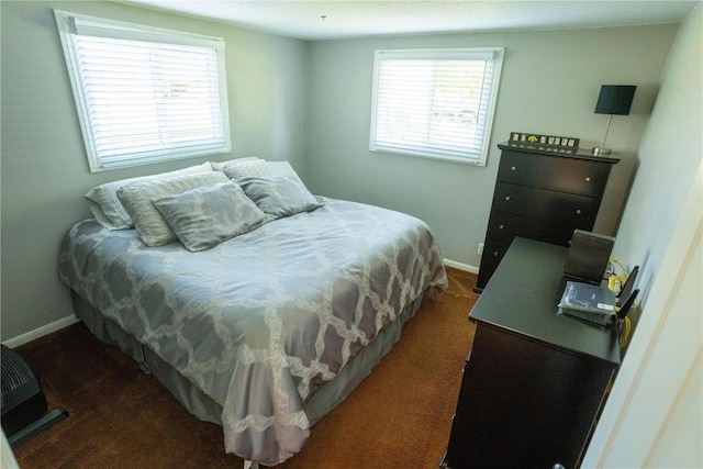 bedroom with multiple windows, baseboards, and dark carpet