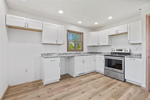 6119 28th Ave Dr, Vinton, IA 52349 - kitchen featuring stainless steel electric stove, white cabinets, light wood-style floors, recessed lighting, and light stone counters