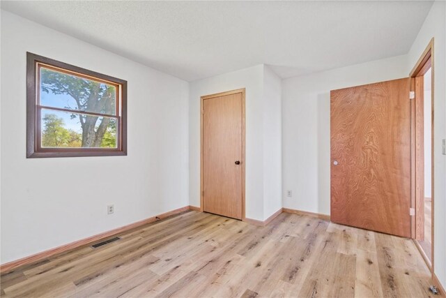 6119 28th Ave Dr, Vinton, IA 52349 - unfurnished bedroom featuring light wood-style flooring and baseboards