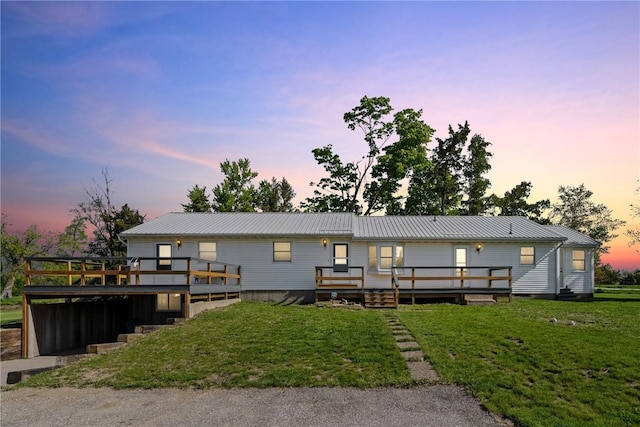 6119 28th Ave Dr, Vinton, IA 52349 - back of house featuring a wooden deck, a lawn, and metal roof