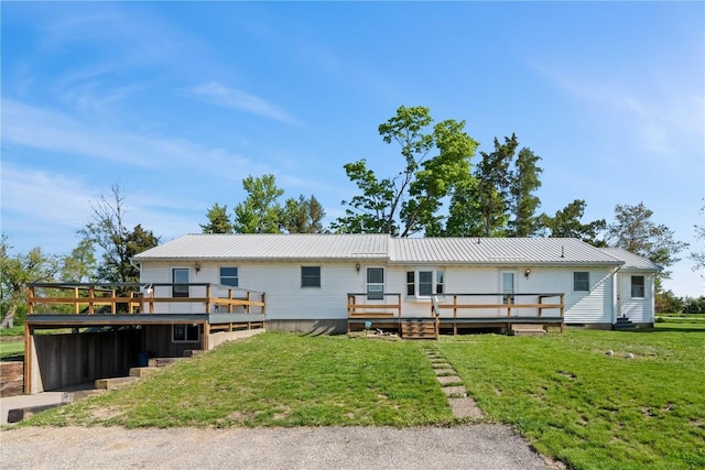 6119 28th Ave Dr, Vinton, IA 52349 - rear view of house with a wooden deck, a lawn, and metal roof