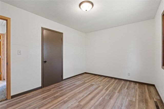 6119 28th Ave Dr, Vinton, IA 52349 - unfurnished bedroom with light wood finished floors, a closet, and baseboards