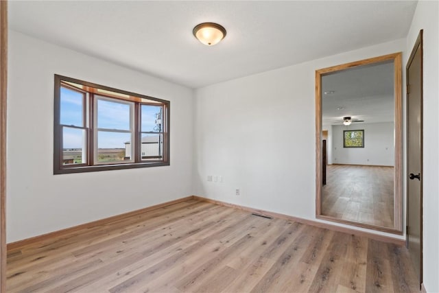 6119 28th Ave Dr, Vinton, IA 52349 - empty room with plenty of natural light, light wood-style floors, and baseboards