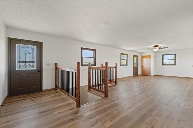 6119 28th Ave Dr, Vinton, IA 52349 - foyer entrance with light wood-style flooring, a textured ceiling, and a ceiling fan