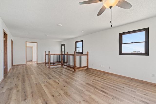 6119 28th Ave Dr, Vinton, IA 52349 - spare room featuring light wood-style floors, baseboards, and a ceiling fan