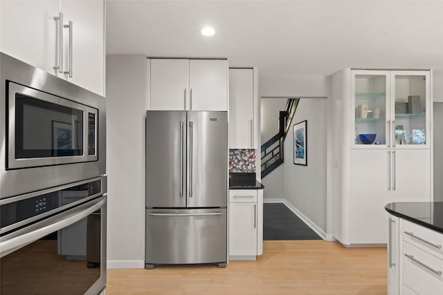 1659 Apache Dr NE, Solon, IA 52333 - kitchen featuring stainless steel appliances, baseboards, white cabinets, light wood-type flooring, and recessed lighting
