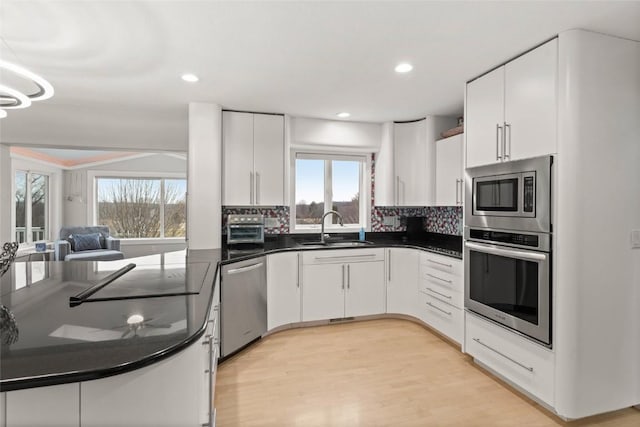 1659 Apache Dr NE, Solon, IA 52333 - kitchen with stainless steel appliances, a sink, dark countertops, plenty of natural light, and recessed lighting