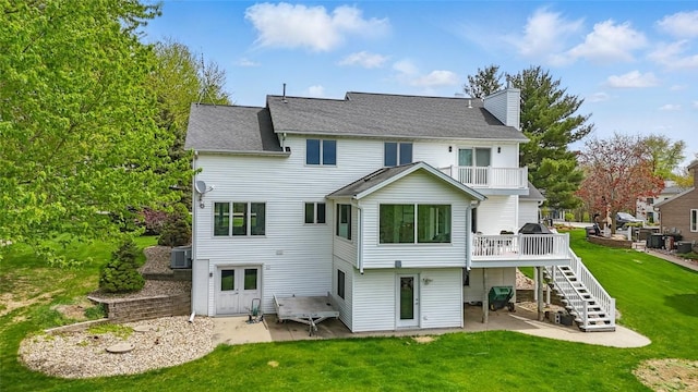 1659 Apache Dr NE, Solon, IA 52333 - back of property featuring a patio area, stairs, a chimney, and a lawn