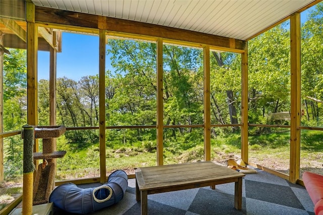 sunroom with plenty of natural light and view of wooded area