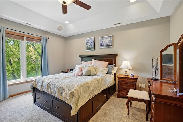 bedroom with light colored carpet, multiple windows, a raised ceiling, baseboards, and recessed lighting