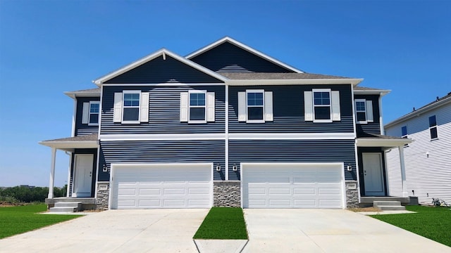 721 Thomas St, Tiffin, IA 52340 - view of front facade with stone siding, driveway, an attached garage, and entry steps