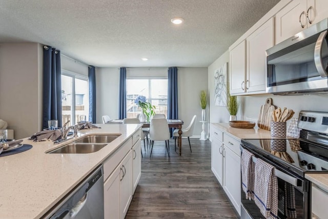 721 Thomas St, Tiffin, IA 52340 - kitchen featuring appliances with stainless steel finishes, a sink, a textured ceiling, white cabinets, and dark wood-type flooring