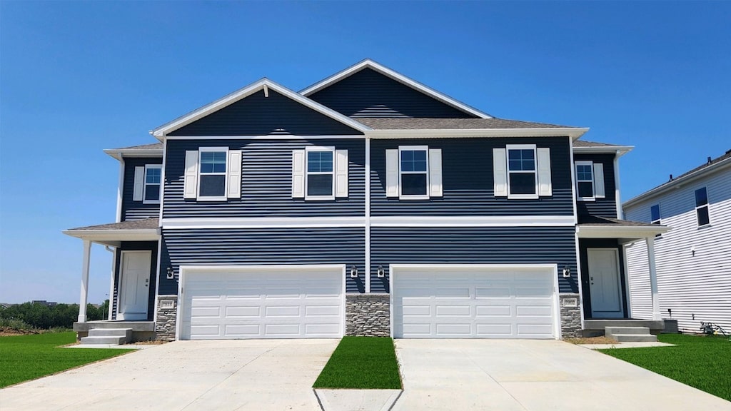 719 Thomas St, Tiffin, IA 52340 - view of front facade with stone siding, driveway, an attached garage, and entry steps