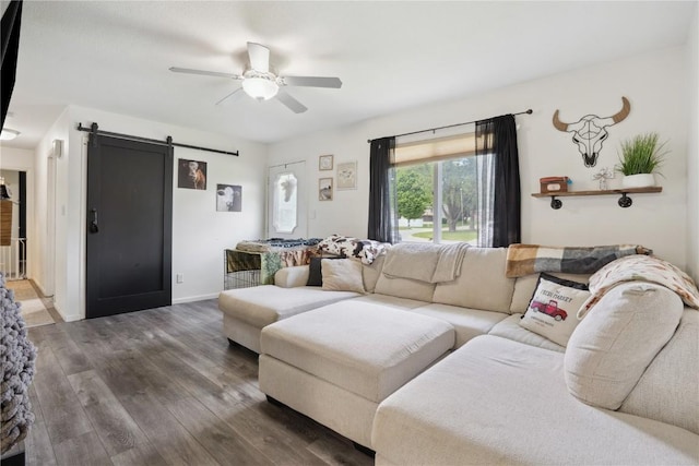906 W 18th St, Vinton, IA 52349 - living area with a barn door, ceiling fan, wood finished floors, and baseboards