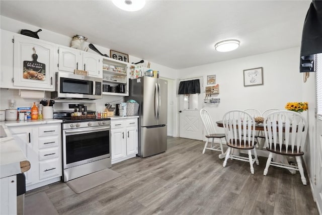 906 W 18th St, Vinton, IA 52349 - kitchen featuring stainless steel appliances, light wood-style flooring, light countertops, and white cabinetry