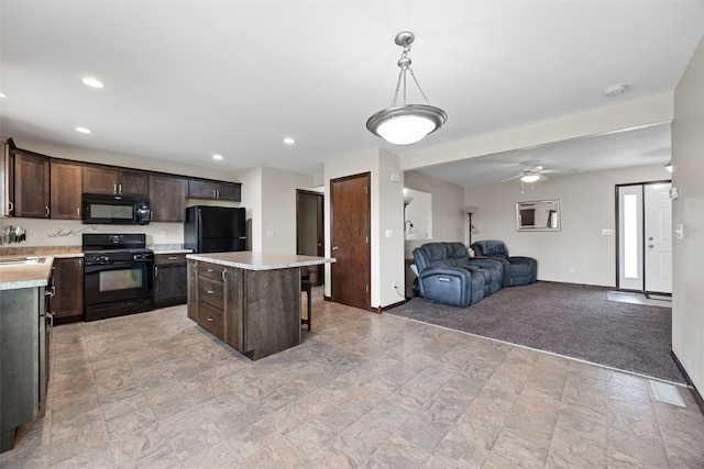 kitchen featuring black appliances, dark brown cabinetry, light countertops, a center island, and recessed lighting