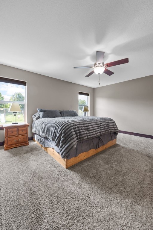 carpeted bedroom with baseboards and a ceiling fan