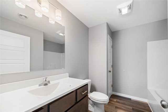 4803 Dostal Ct, Cedar Rapids, IA 52404 - full bathroom with wood finished floors, baseboards, toilet, vanity, and a tub