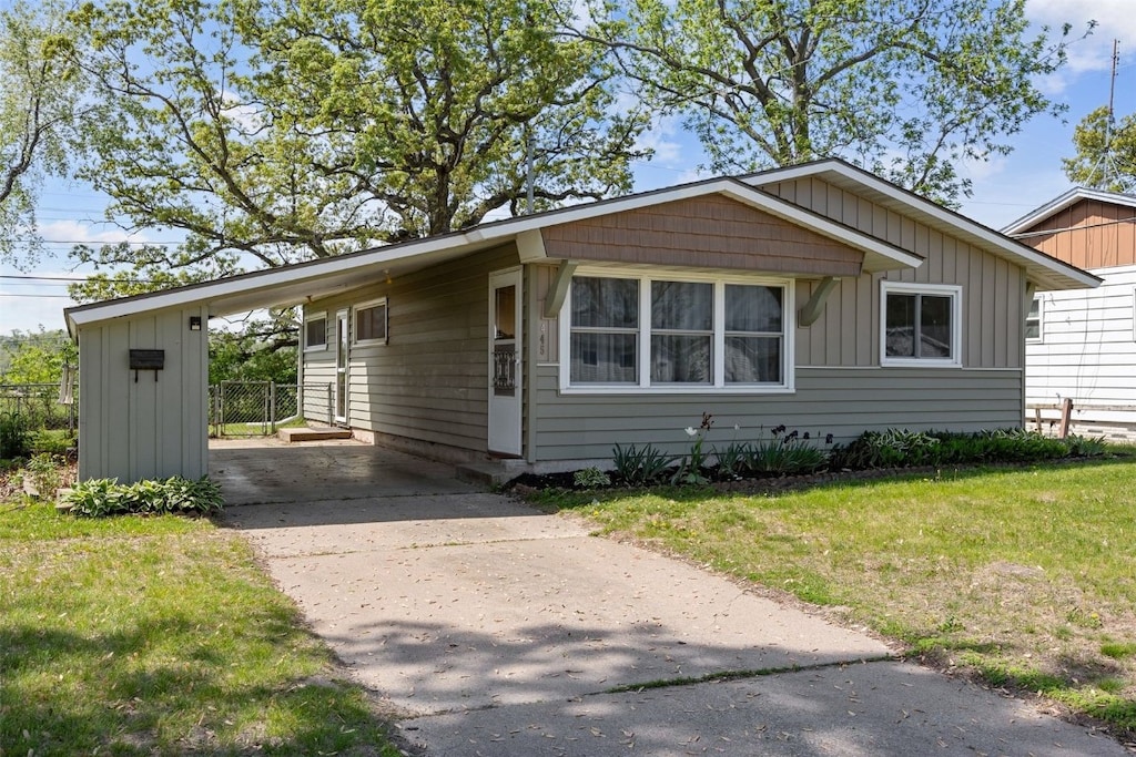 view of front of house featuring concrete driveway, an attached carport, and board and batten siding