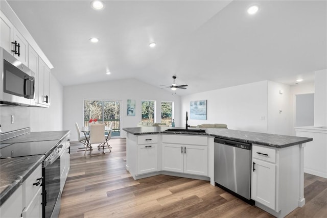 kitchen with appliances with stainless steel finishes, a sink, a ceiling fan, lofted ceiling, and light wood-style flooring